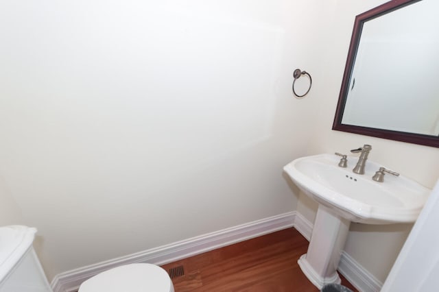 bathroom with visible vents, wood finished floors, toilet, and baseboards