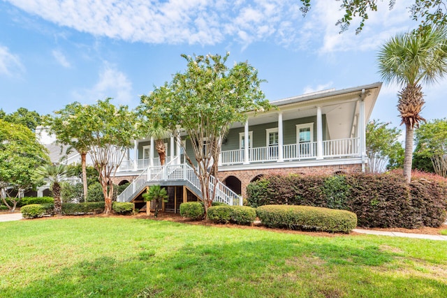 view of front of home featuring a front yard, covered porch, and stairs