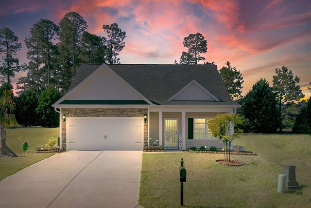224 Young Town Cir, Orangeburg, SC 29118 - view of front of house featuring a lawn, driveway, stone siding, a porch, and a garage