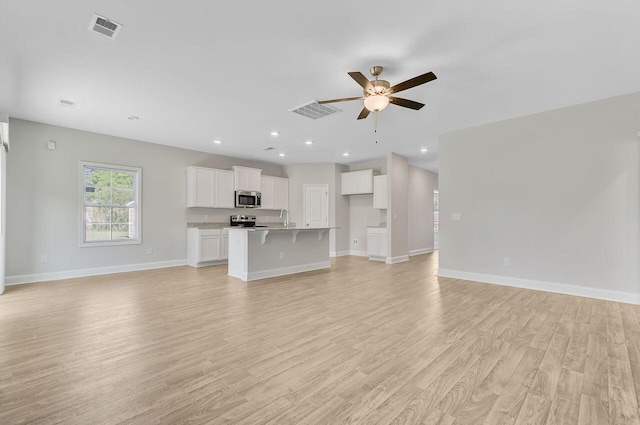 224 Young Town Cir, Orangeburg, SC 29118 - unfurnished living room with ceiling fan, baseboards, light wood-style floors, and visible vents