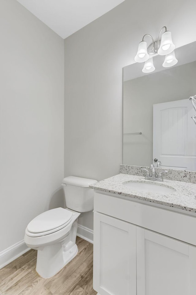 224 Young Town Cir, Orangeburg, SC 29118 - bathroom with wood finished floors, toilet, vanity, baseboards, and a chandelier