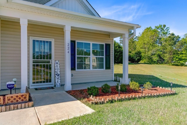 224 Young Town Cir, Orangeburg, SC 29118 - view of exterior entry with board and batten siding, a yard, and covered porch