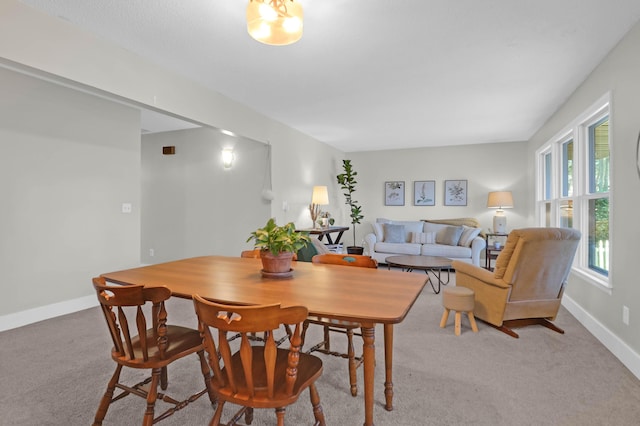 dining room with light colored carpet and baseboards