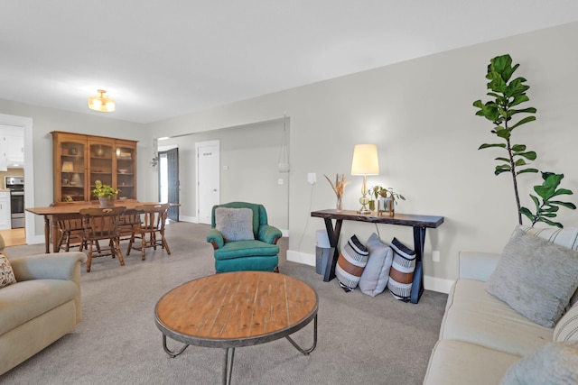 carpeted living area with baseboards