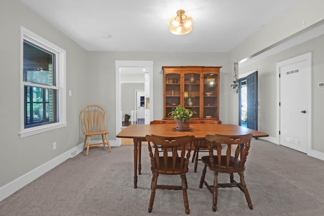 carpeted dining space with visible vents and baseboards