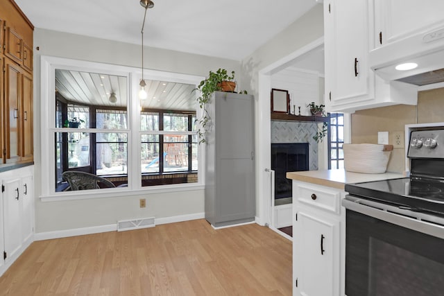 kitchen with under cabinet range hood, visible vents, stainless steel electric stove, and a healthy amount of sunlight