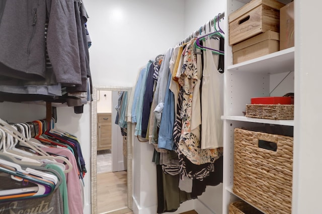 walk in closet with wood finished floors