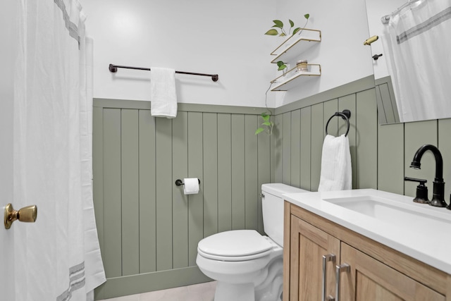 full bath with vanity, toilet, and wainscoting