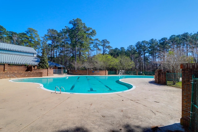 pool featuring a patio area and fence