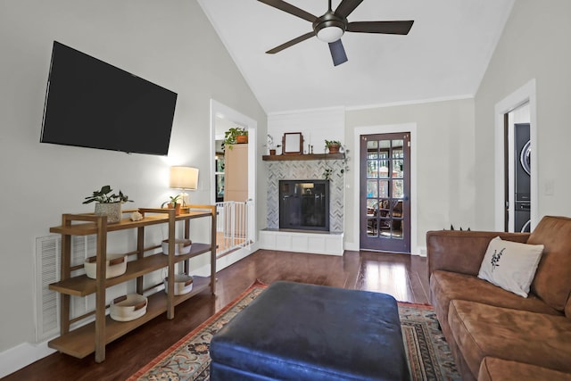 living room with a fireplace, wood finished floors, a ceiling fan, and vaulted ceiling