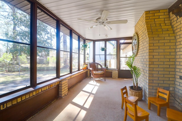 sunroom / solarium featuring a ceiling fan