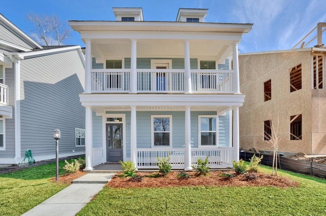 view of front of property featuring a balcony, a porch, and a front lawn