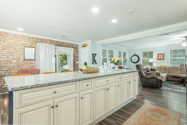 kitchen featuring light stone countertops, a center island, and cream cabinetry