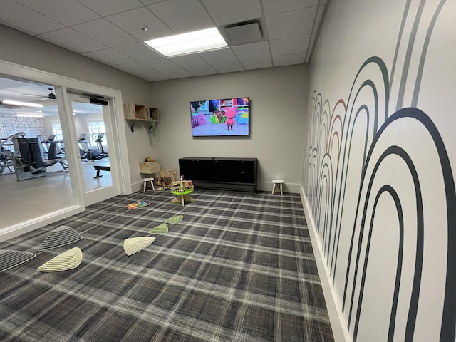 interior space with dark colored carpet and a paneled ceiling