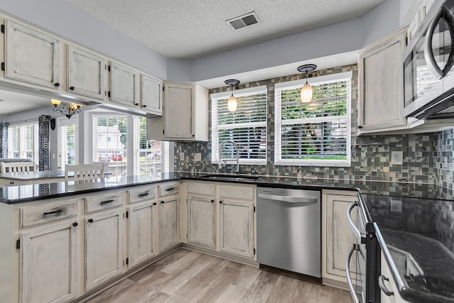 100 Conset Bay Ct, Goose Creek, SC 29445 - kitchen with appliances with stainless steel finishes, a peninsula, a sink, backsplash, and a textured ceiling