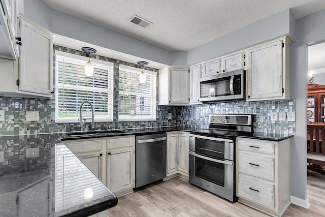 100 Conset Bay Ct, Goose Creek, SC 29445 - kitchen featuring stainless steel appliances, a sink, decorative backsplash, light wood-type flooring, and a textured ceiling