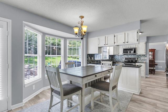 100 Conset Bay Ct, Goose Creek, SC 29445 - dining area with a chandelier, light wood-type flooring, baseboards, and a textured ceiling
