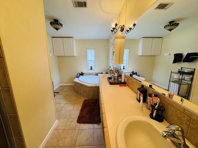 bathroom with a relaxing tiled tub, tile patterned floors, and vanity