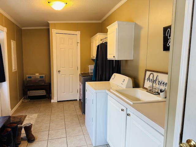 washroom with light tile patterned flooring, washing machine and clothes dryer, sink, cabinets, and ornamental molding