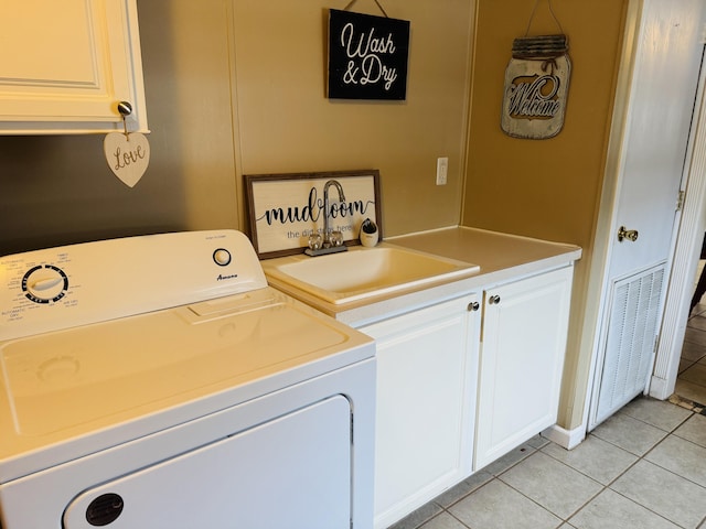 washroom featuring light tile patterned flooring, cabinets, washer / dryer, and sink