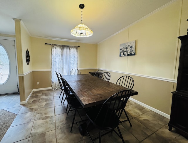 dining area featuring crown molding and dark tile patterned flooring