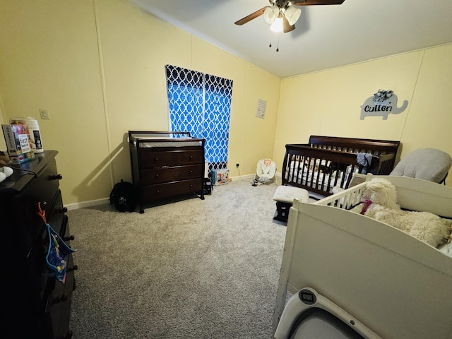 carpeted bedroom with a nursery area and ceiling fan