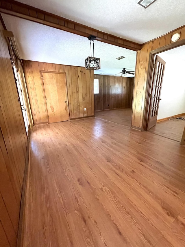 6287 Sniders Hwy, Walterboro, SC 29488 - spare room with light wood-style floors, wood walls, baseboards, a textured ceiling, and a ceiling fan