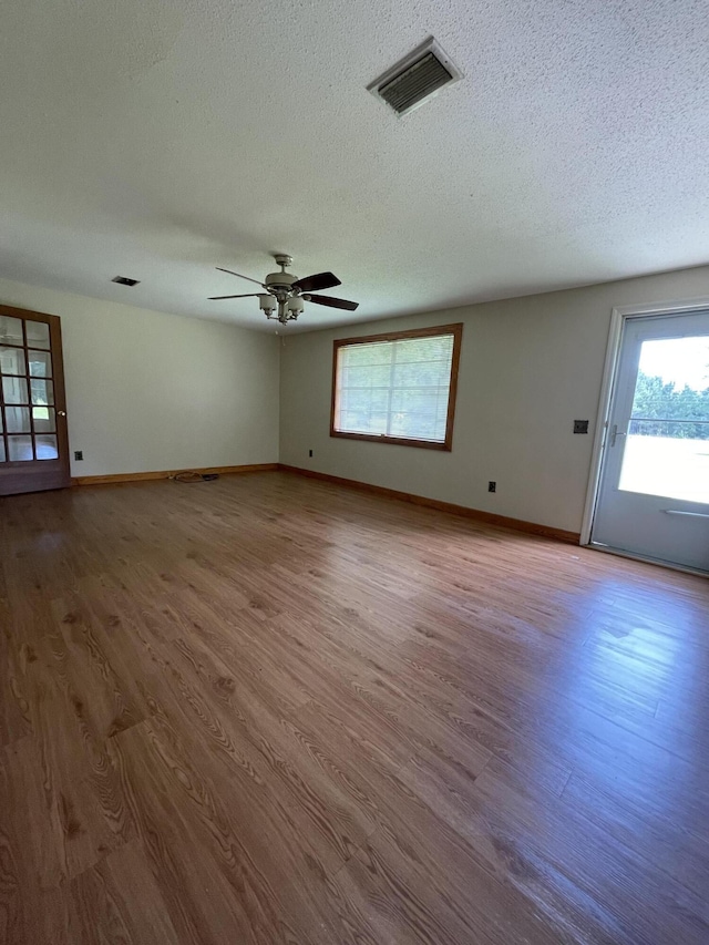 6287 Sniders Hwy, Walterboro, SC 29488 - unfurnished room with healthy amount of natural light, wood finished floors, a textured ceiling, and baseboards