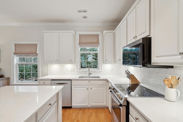 kitchen with ornamental molding, stainless steel appliances, sink, and white cabinets