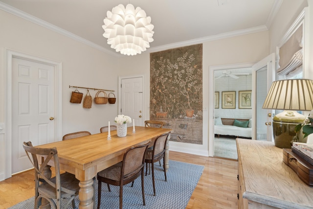 dining space featuring ornamental molding, a notable chandelier, and light wood-type flooring