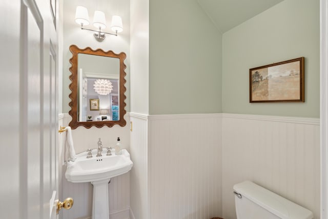 bathroom with vaulted ceiling, sink, and toilet