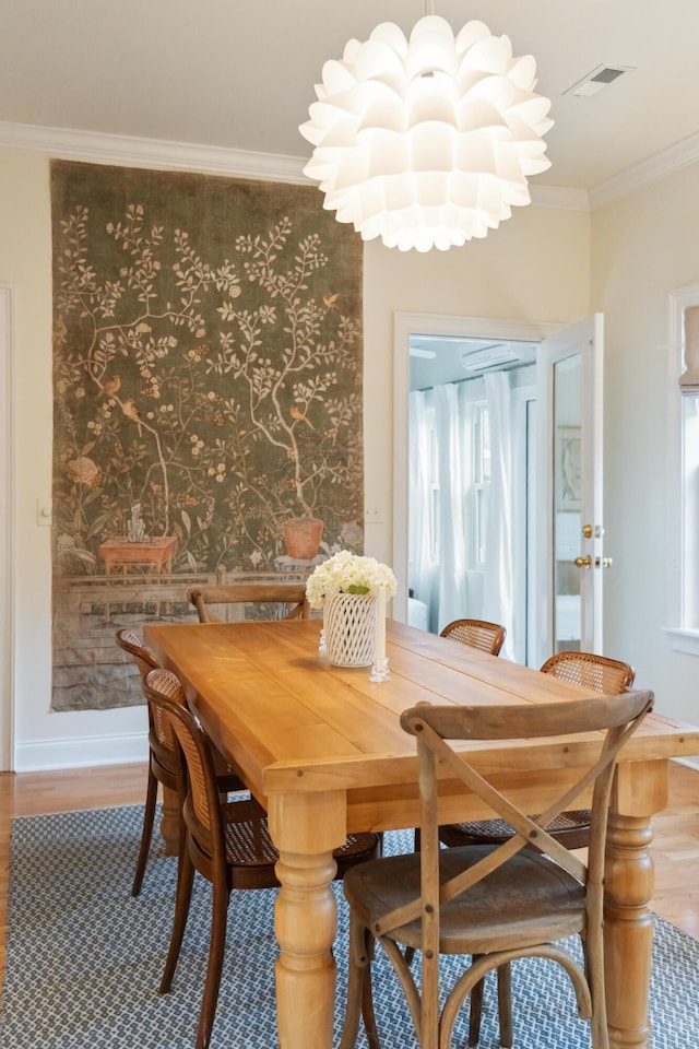 dining room with hardwood / wood-style flooring and ornamental molding