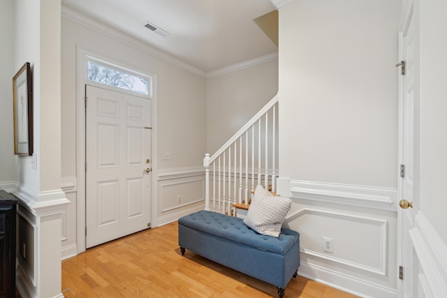 entryway featuring ornamental molding and light wood-type flooring