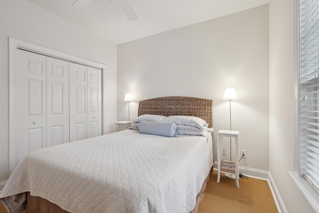 carpeted bedroom with ceiling fan and a closet