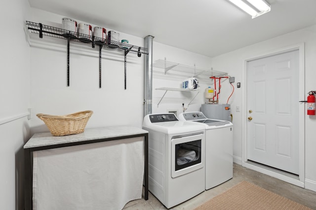 laundry area with electric water heater and washer and dryer