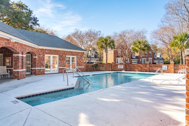 view of swimming pool featuring french doors and a patio area