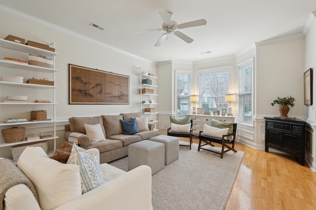 living room with light hardwood / wood-style flooring, ornamental molding, and ceiling fan