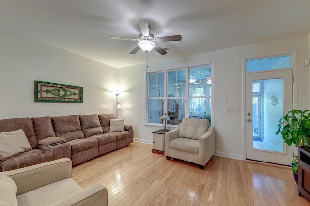 living room featuring ceiling fan, light wood-style flooring, and baseboards