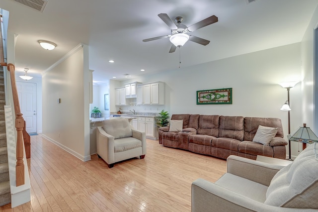 living room with light wood finished floors, stairway, visible vents, and baseboards