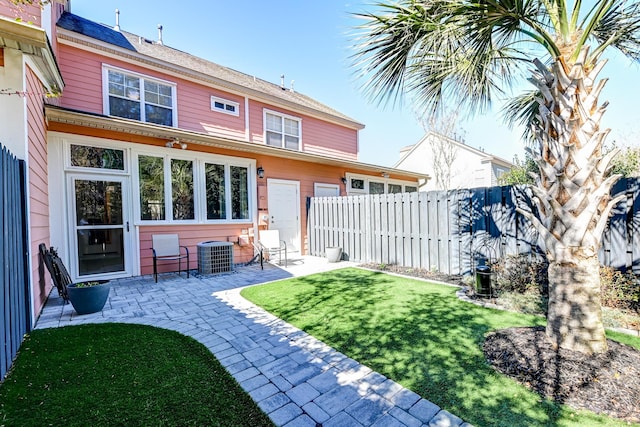 rear view of house featuring a yard, a patio area, fence, and central air condition unit