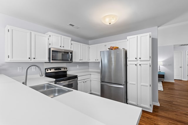 kitchen with visible vents, stainless steel appliances, light countertops, white cabinetry, and a sink