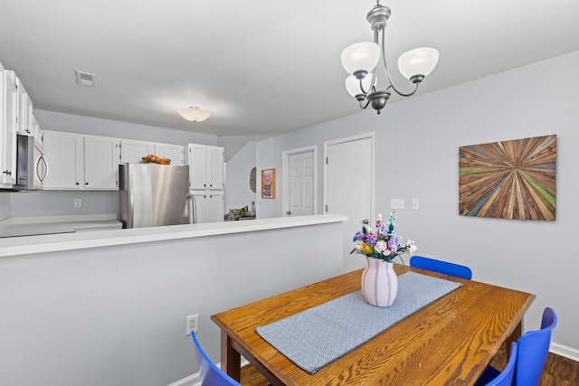 dining room featuring baseboards, visible vents, and a chandelier