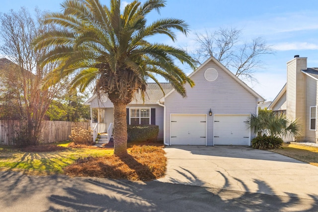 view of front of home with a garage, fence, and driveway