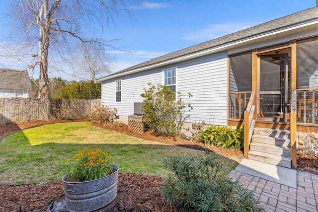 view of yard with fence and a sunroom