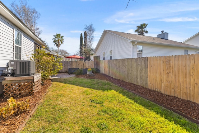 view of yard featuring a fenced backyard and central AC unit