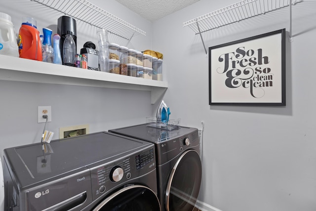 clothes washing area featuring laundry area, a textured ceiling, and separate washer and dryer