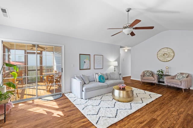 living area featuring visible vents, a ceiling fan, vaulted ceiling, wood finished floors, and baseboards