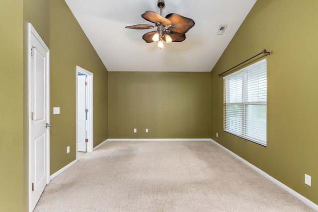 carpeted spare room featuring ceiling fan and vaulted ceiling