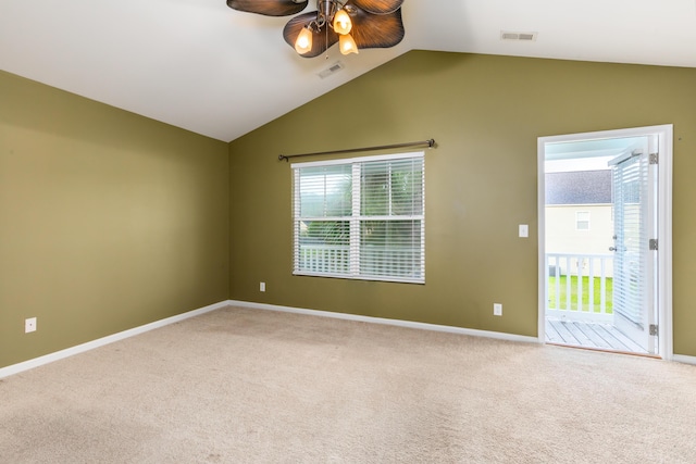 spare room with ceiling fan, a wealth of natural light, vaulted ceiling, and carpet flooring