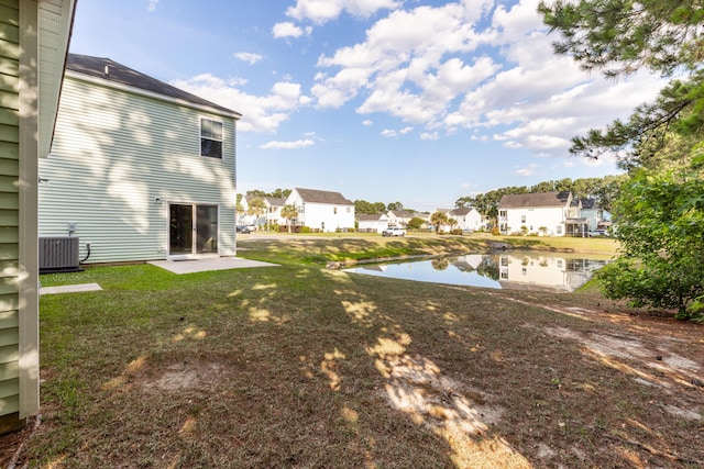 view of yard featuring a water view and central AC unit